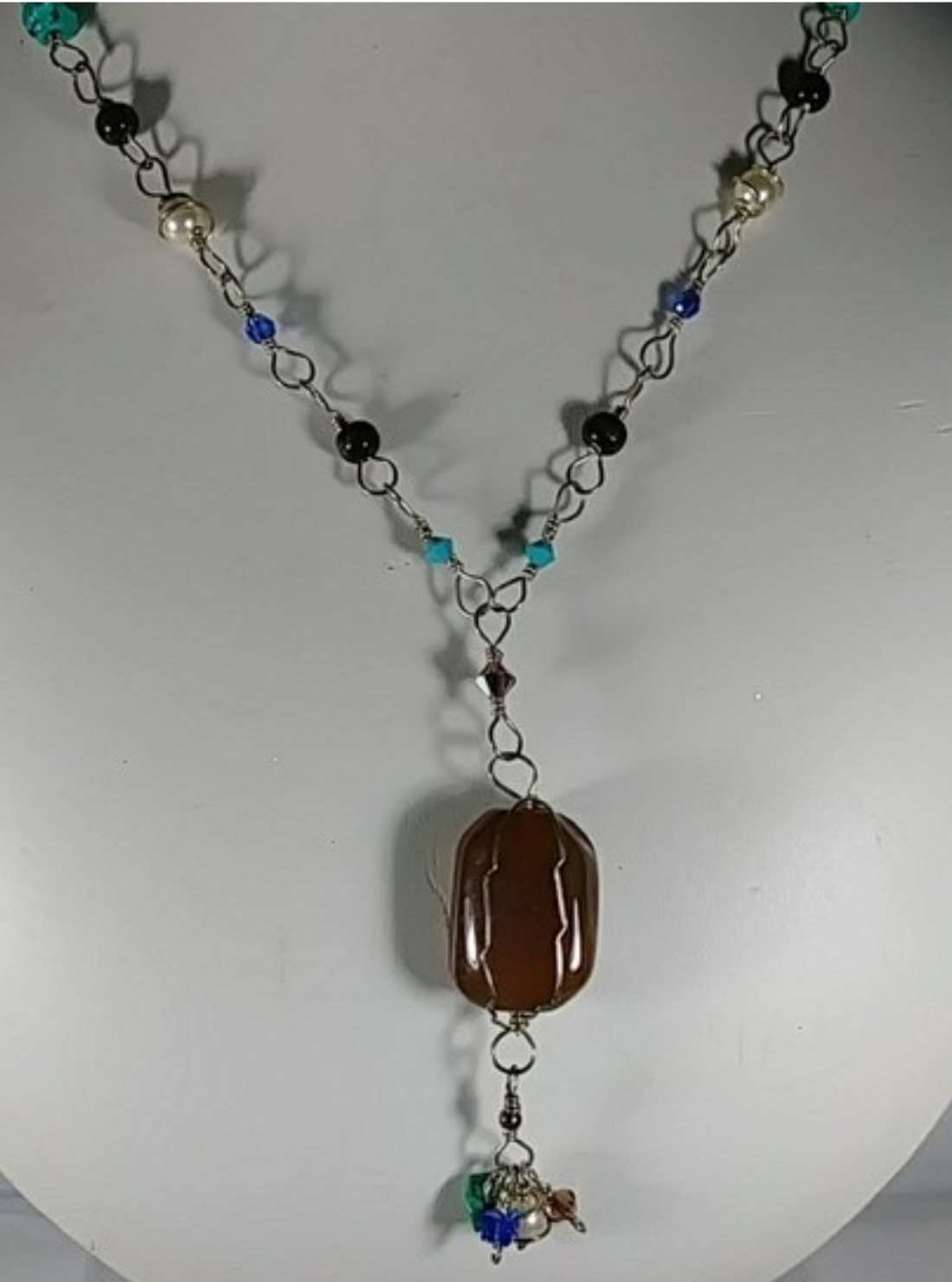 (302 -NCK) - Description: Sterling Silver Necklace, Handcrafted Chain, Turquoise & Tigers Eye Gemstones, Swarovski Crystal and Swarovski Crystal Pearl Beads, Wood Mask Beads - Large Carnelian Gemstone Focal Bead. Dimension: 24' L (Inches