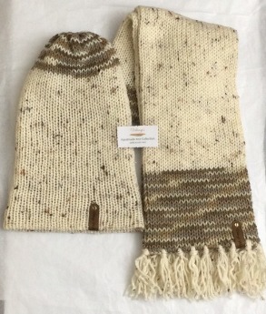 - Unisex Accessory -Material: 100% Acrylic Yarn, Custom Riveted Faux Leather Tags Construction: Double Layered Knit Scarf and Beanie    Color(s): Aran Tweed and Toasted Almond  Size: OS Stretchable 